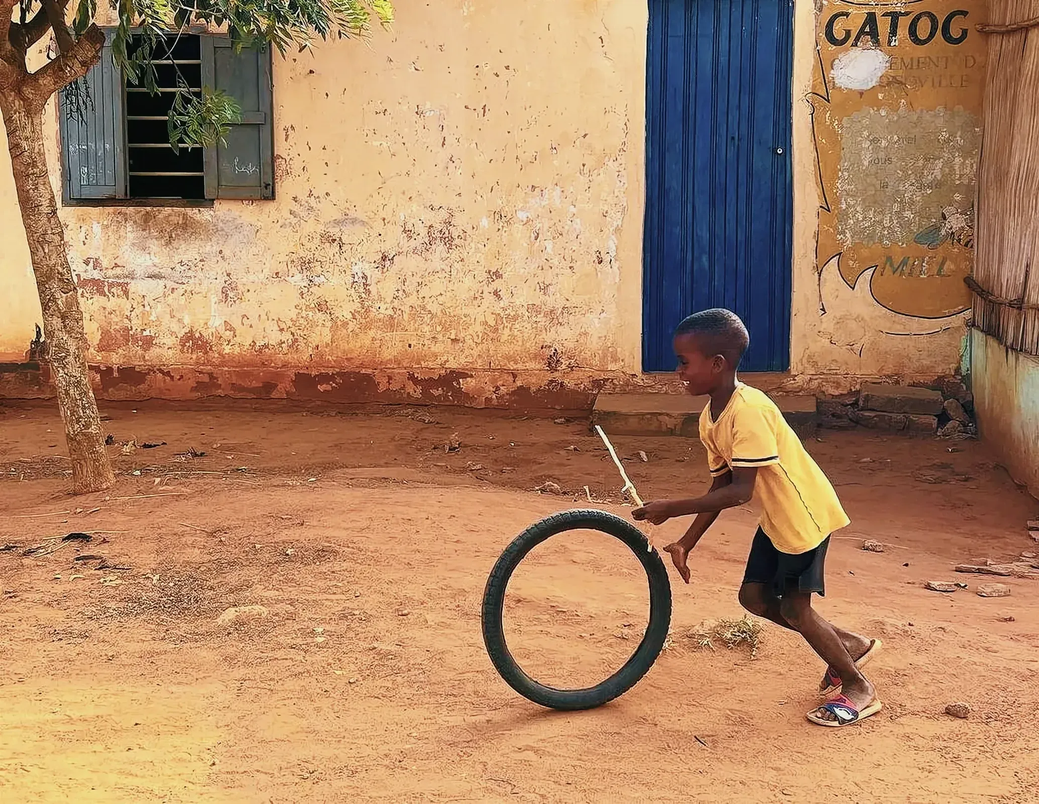 A young boy pushing a tire in Togoville, Togo