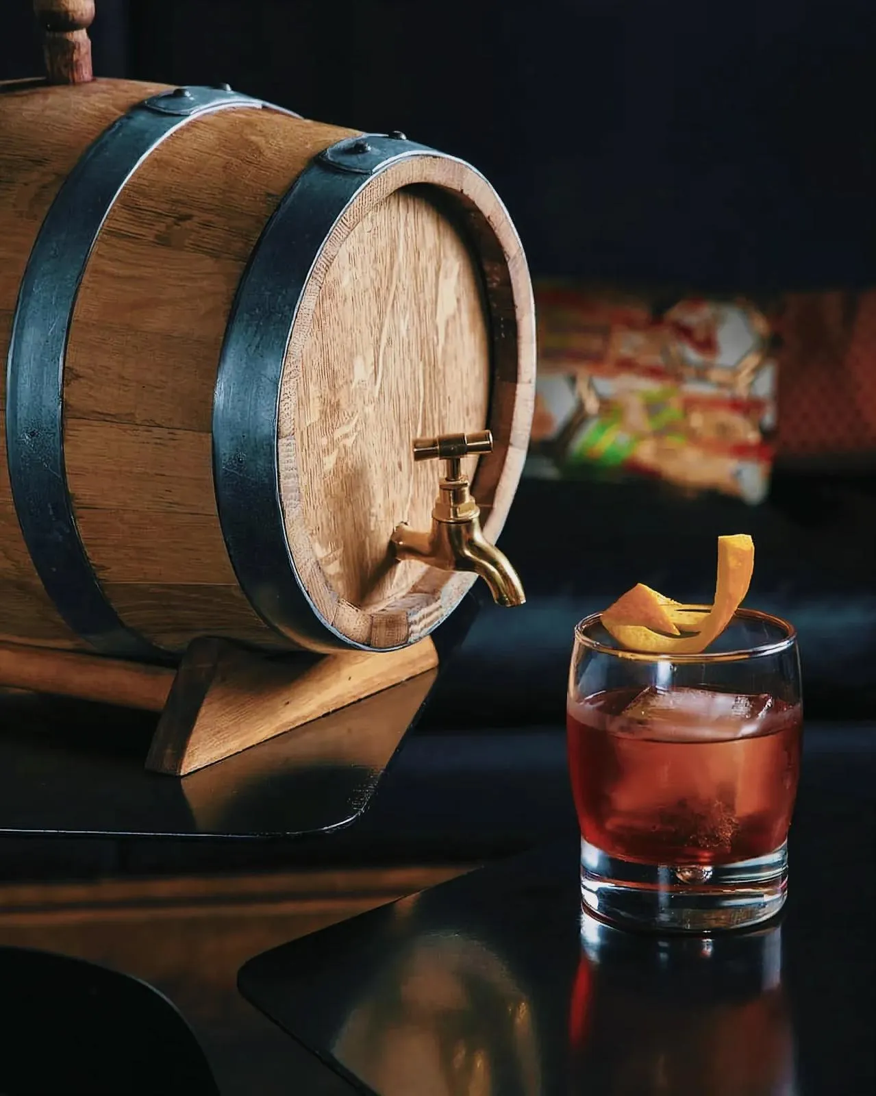 Rustic wooden barrel and glass with whiskey on a table