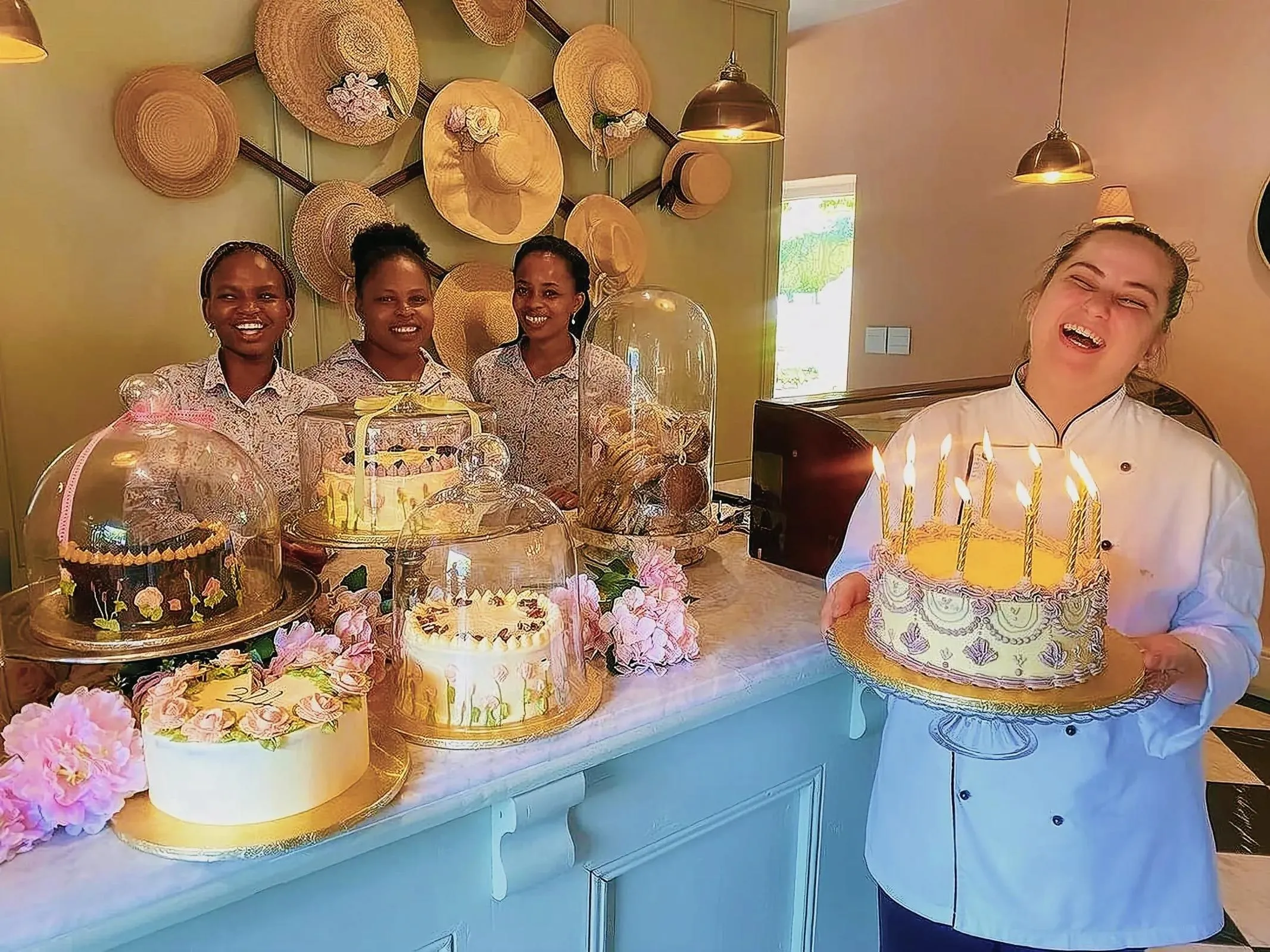 Four women celebrating a birthday in a cozy kitchen with cakes and decorations