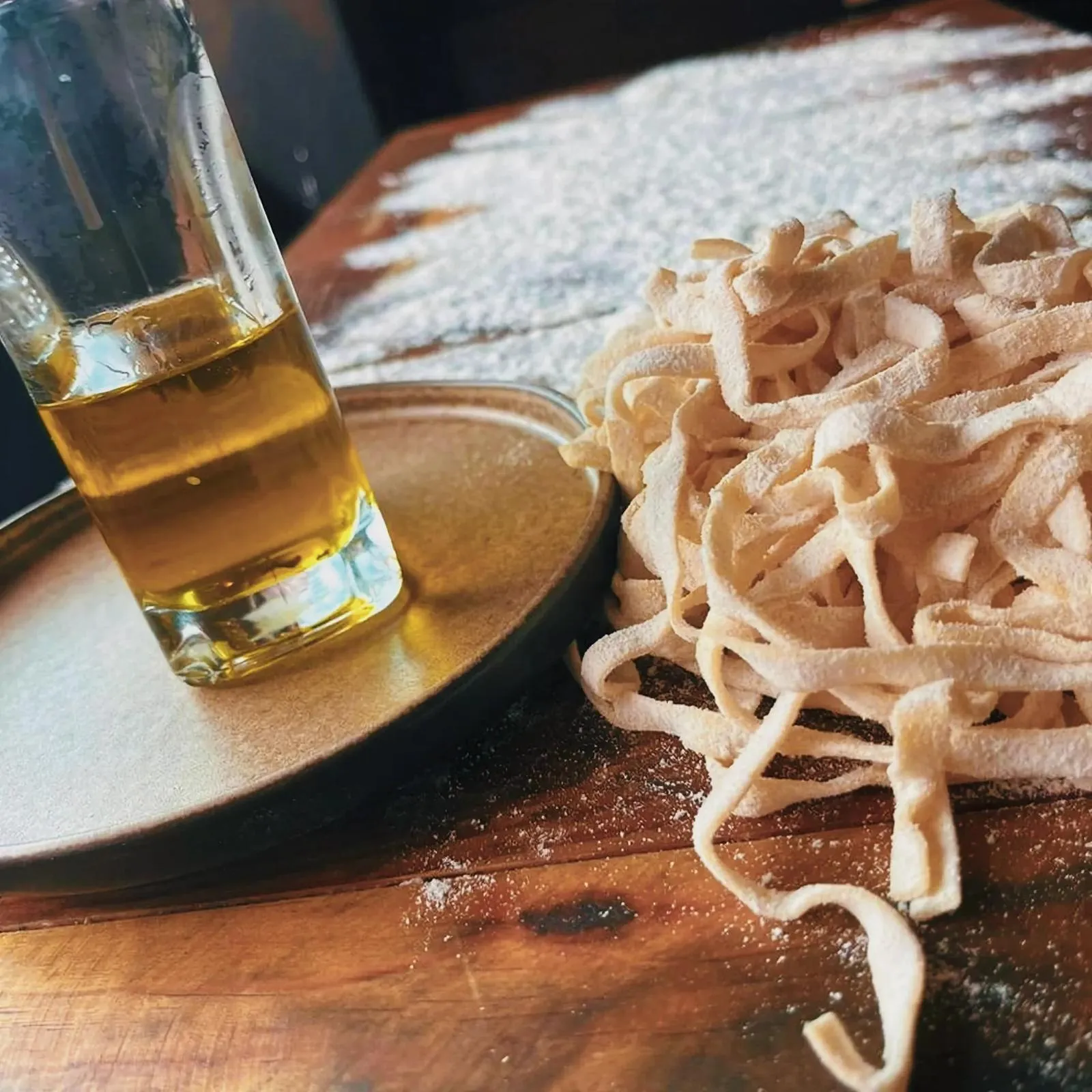 Tantalizing Tagliolini pasta and oil on a wooden table.